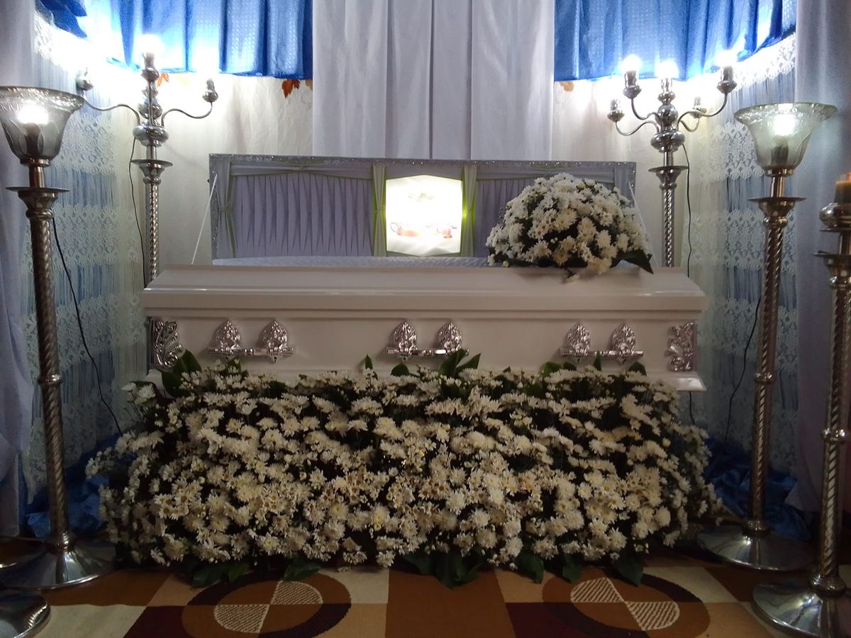 Bed of white chrysanthemums in front of the casket at a wake