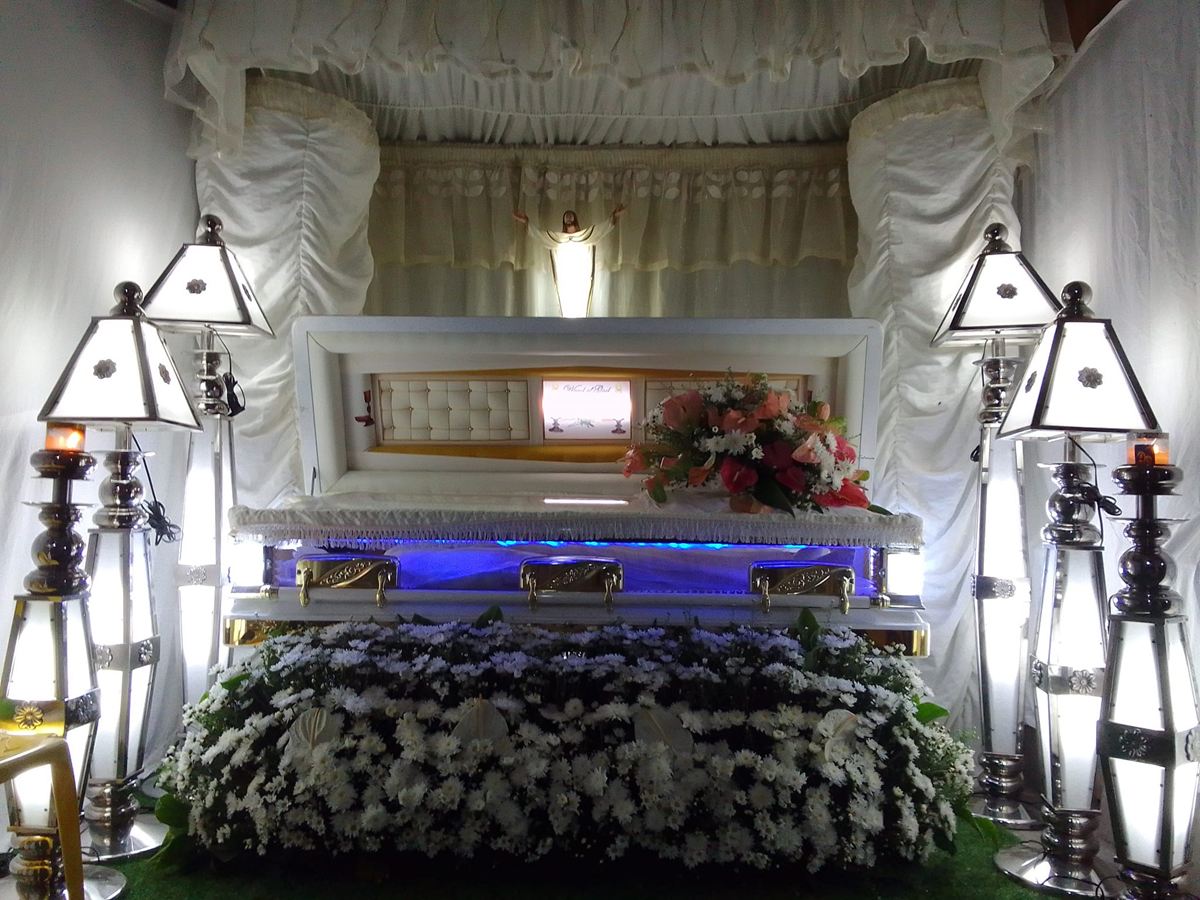 Viewing area with white drapes, lamps and flowers prepared by Libintia Caja Mortuary Care