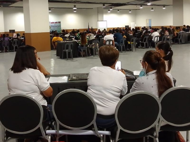 Libintia Caja staff at a help desk with forms