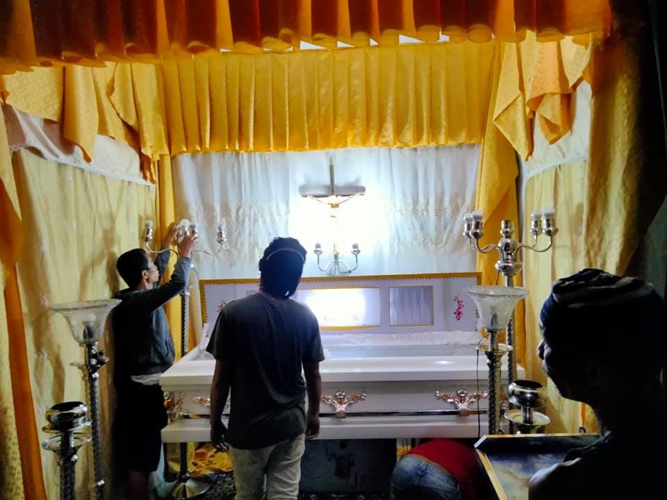 Libintia Caja team setting up the lights and drapes for a home wake